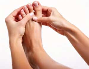 Kvinde trykker på sin fod med nerveknude (mortons neurom),